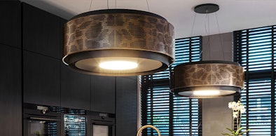Design afzuigkap met geïntegreerde afzuiglamp en sfeervolle verlichting boven een kookeiland