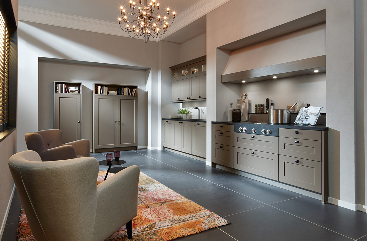 Landelijke taupekleurige keuken met zwart blad.