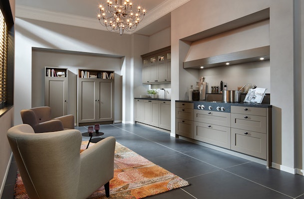 Landelijke taupekleurige keuken met zwart blad.