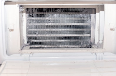 Hand die de condensor van een droger schoonmaakt met een groene doek voor langere levensduur