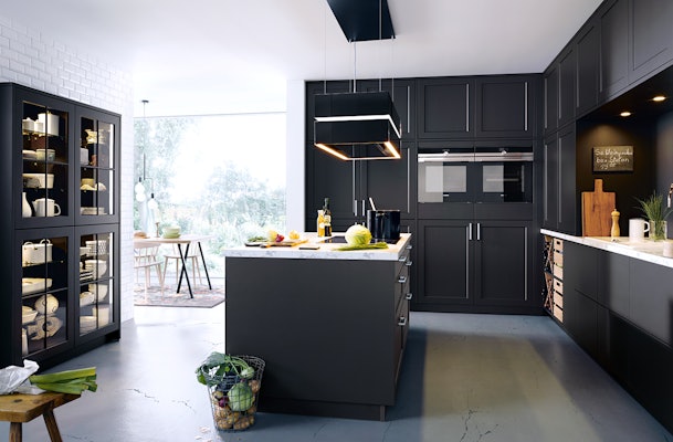 Lavazwarte keuken met wit marmeren werkbladen.