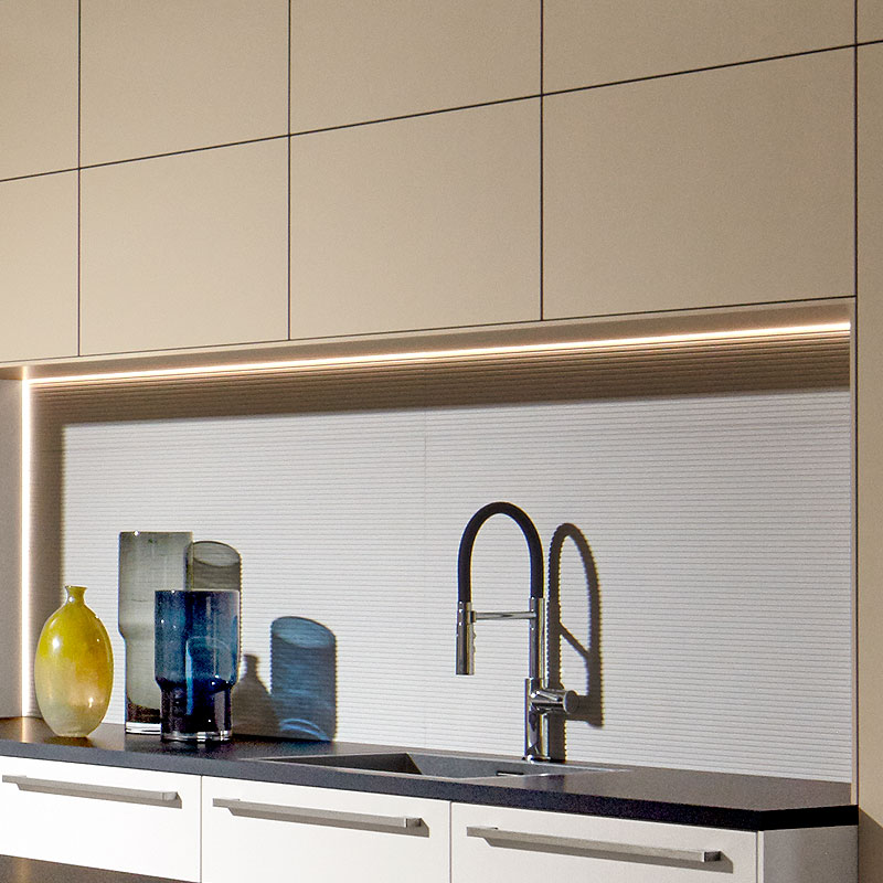 Doorlopende LED-nisverlichting boven spoelzone.