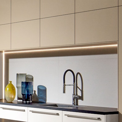 Doorlopende LED-nisverlichting boven spoelzone.