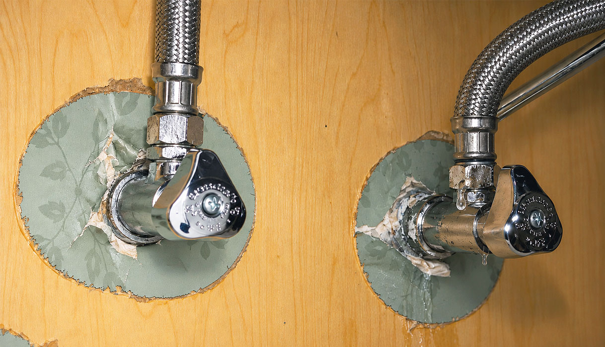 Druppelende koppeling tussen hoekstopkraan en flexibele aansluitslang onder het aanrecht bij een lekkende keukenkraan