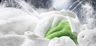 Stoom die door wit en groen wasgoed in een LG wasmachine trommel stroomt voor hygiënisch wassen