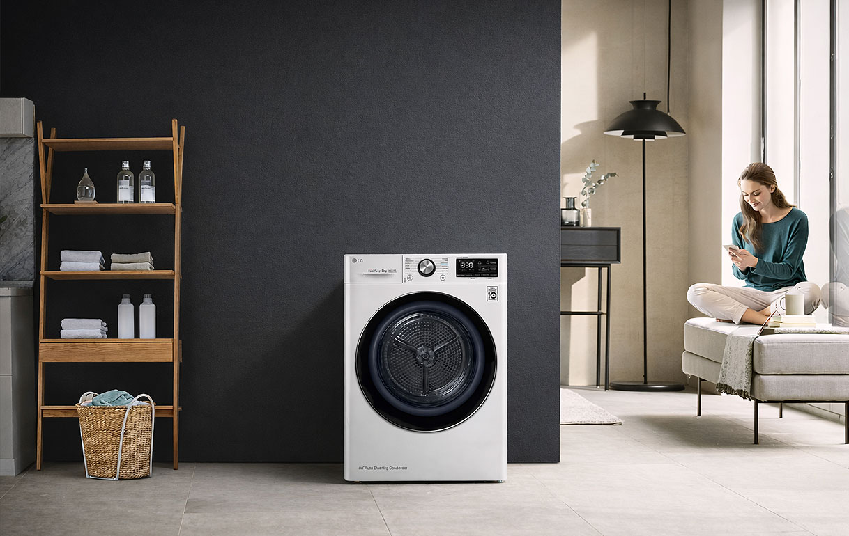 LG ThinQ droger in een wasruimte met een vrouw die de droger op afstand bedient via de app