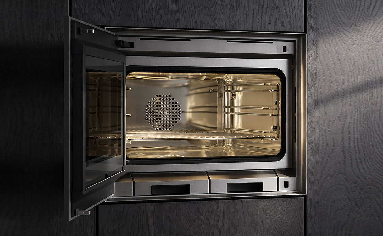 Gaggenau combimagnetron met volledig geopende deur links of rechts draaiend ingebouwd in donkere keuken