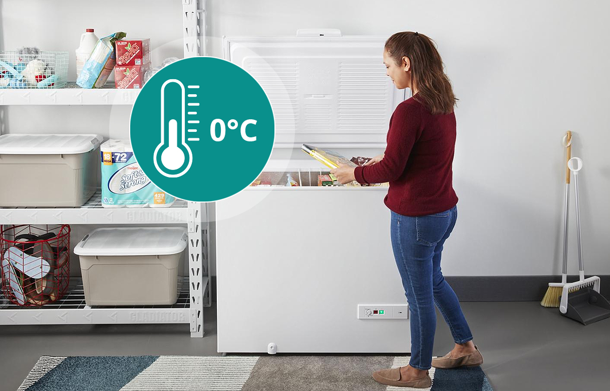 Vrouw opent een vrieskist in een onverwarmde schuur met 0 graden pictogram, geschikt voor gebruik vanaf 0 °C omgevingstemperatuur