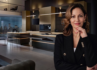 Luxe keuken van Bemmel & Kroon in donkere tinten met goudkleurige accenten en uitzicht op de skyline