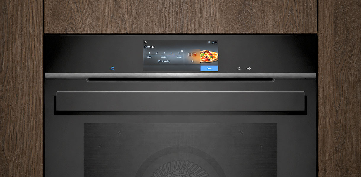 Mat afgewerkte inbouwmagnetron met touchscreen ingebouwd in een houten keukenkast