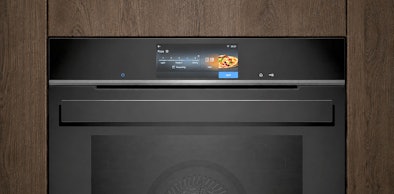Mat afgewerkte inbouwmagnetron met touchscreen ingebouwd in een houten keukenkast