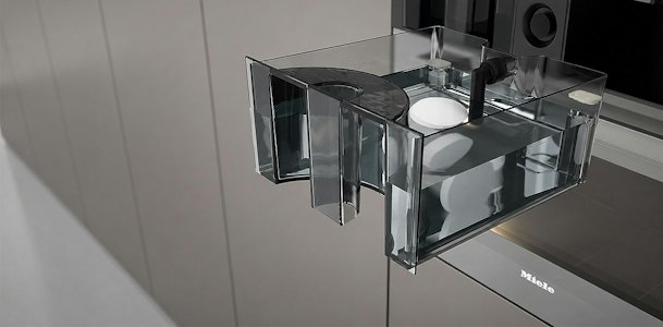 Transparant waterreservoir uit een stoomapparaat met de klep open voor onderhoud