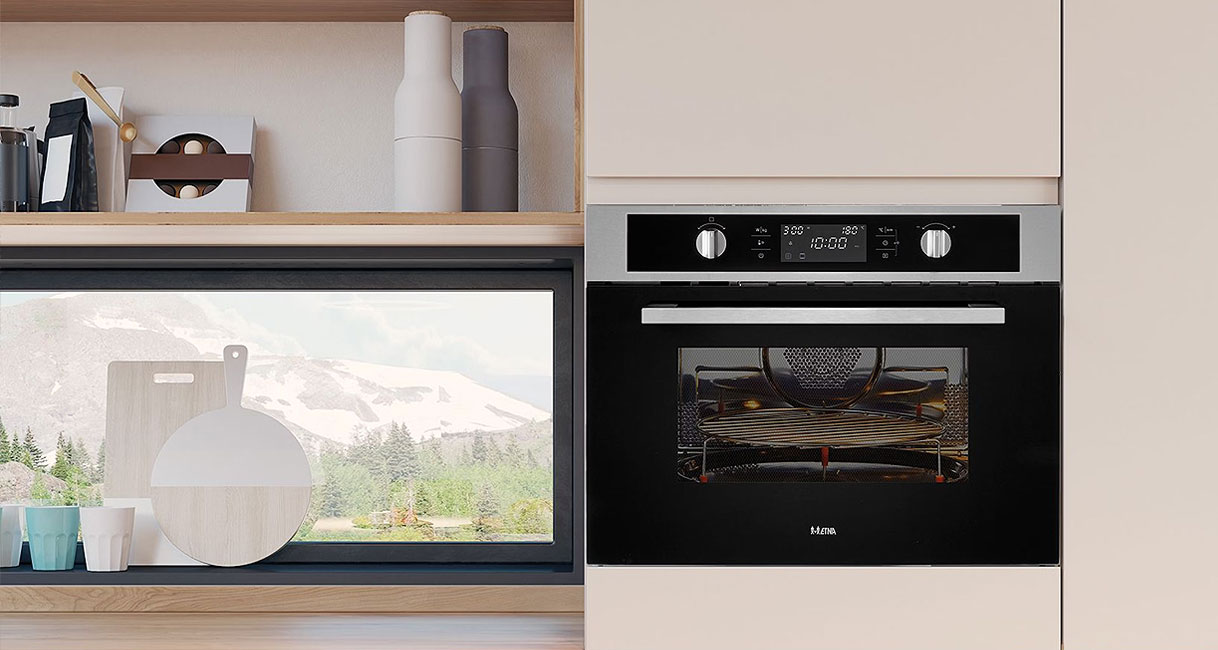 Etna combimagnetron in zwart met grillelement ingebouwd in moderne keuken met houten accessoires