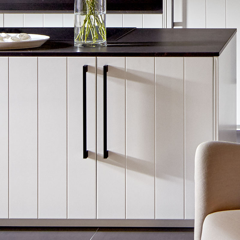 Mat arctiswitte lamelfronten met hoge zwarte grepen.