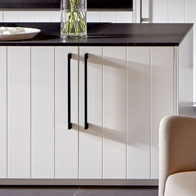 Mat arctiswitte lamelfronten met hoge zwarte grepen.