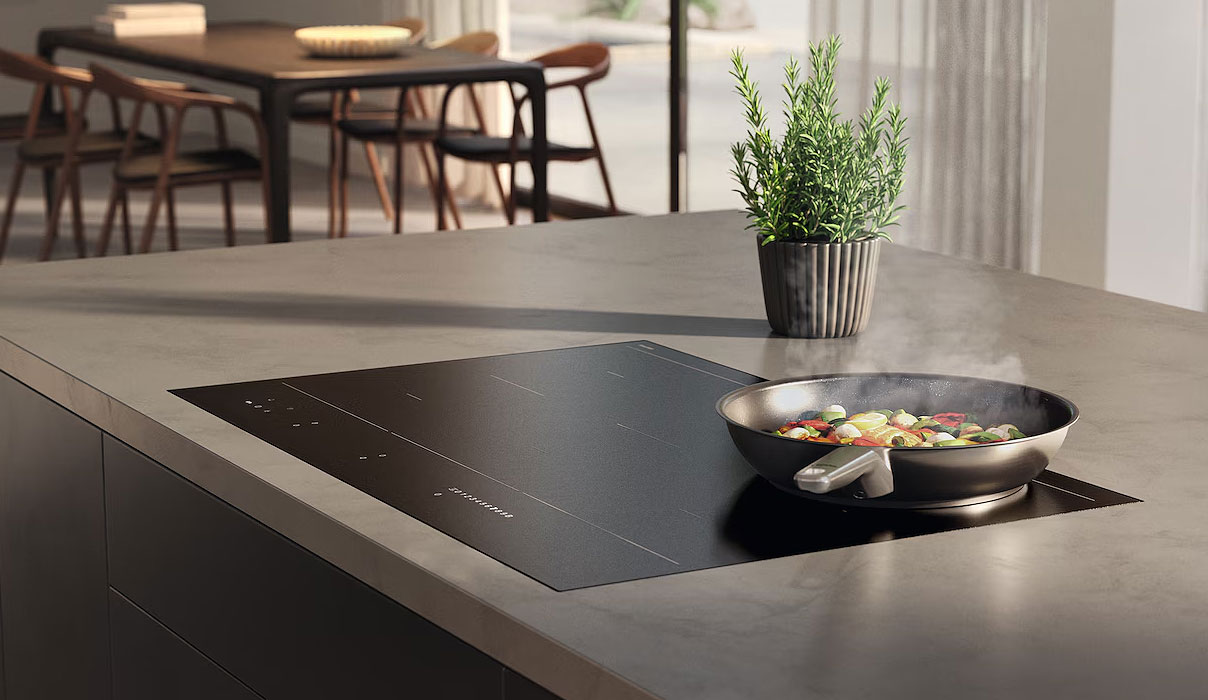 Miele MattFinish inductiekookplaat met matte afwerking en koekenpan in moderne keuken