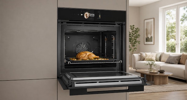 Bosch combimagnetron met gebraden kip en kerntemperatuurmeter in een moderne taupe keuken.