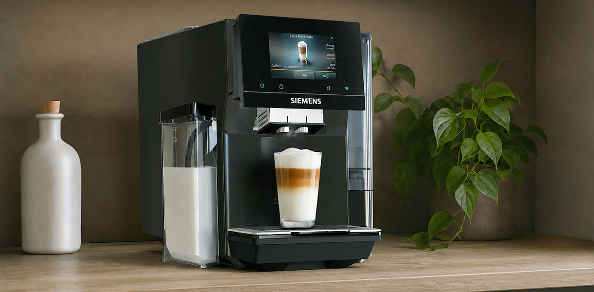 Siemens koffiemachine met geïntegreerd melkreservoir dat een latte macchiato zet op het aanrecht