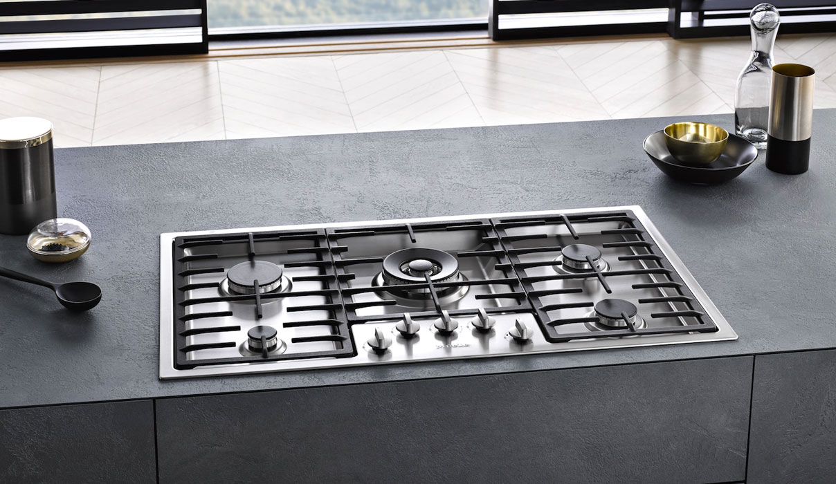 Moderne Miele gaskookplaat met vijf branders en gietijzeren pannendragers in luxe keukenblad