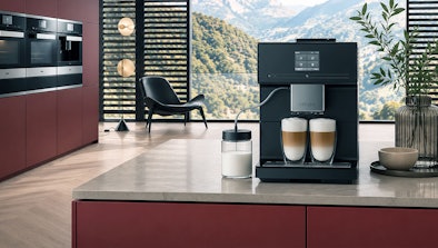 Twee Miele CM 7000 koffiemachines uit de CoffeePassion en CoffeeSelect reeks met cappuccino's op een aanrecht