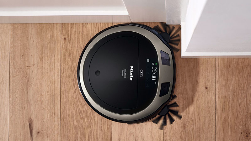 Miele robotstofzuiger aan het reinigen van houten vloer langs de plint