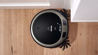 Miele robotstofzuiger aan het reinigen van houten vloer langs de plint