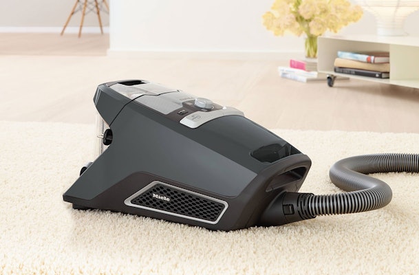 Miele stofzuiger zonder zak met doorzichtige stofcontainer op zacht vloerkleed