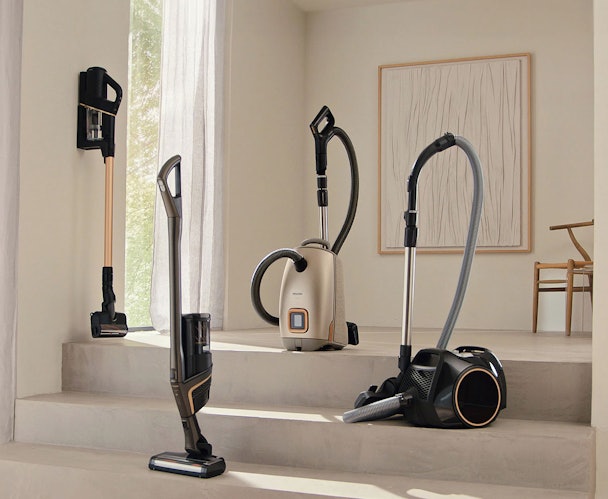 Miele stofzuiger collectie met steelstofzuiger sledestofzuiger en zakloze modellen in moderne woonkamer
