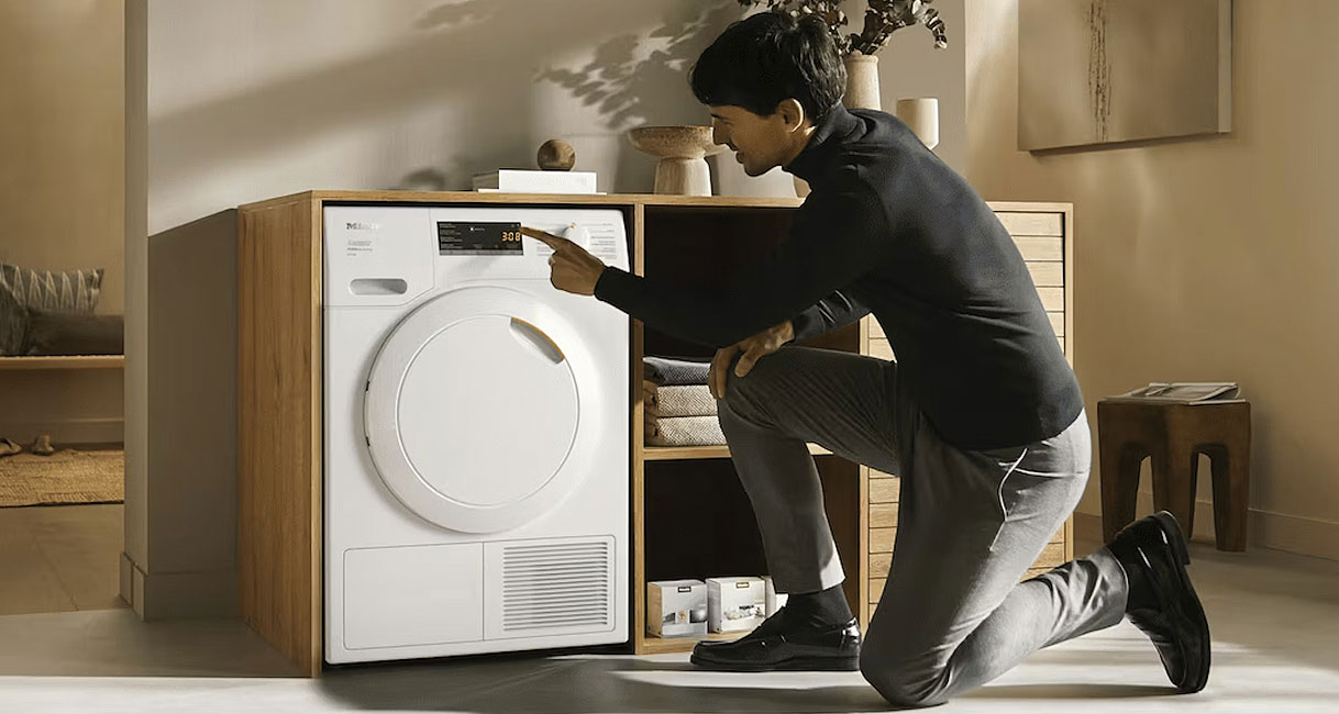 Man bedient Miele warmtepompdroger van 8 kg in moderne woonkamer