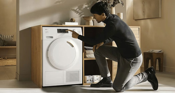 Man bedient Miele warmtepompdroger van 8 kg in moderne woonkamer