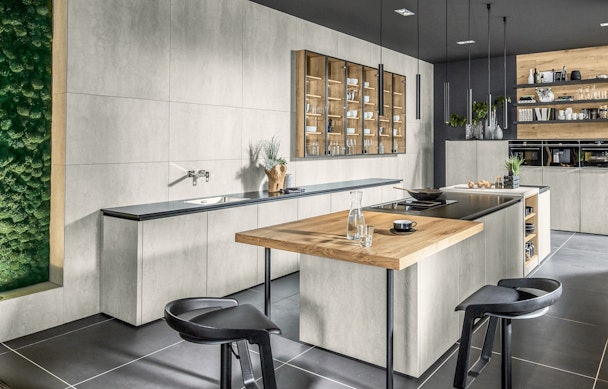 Een mix & match keuken met een houten werkblad en een betonnen achterwand.