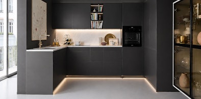 Moderne hoekkeuken met donkere fronten en geïntegreerde verlichting onder bovenkasten