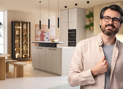 Moderne keuken van Bemmel & Kroon in lichtgrijs met kookeiland, verlichte vitrinekast en houten accenten