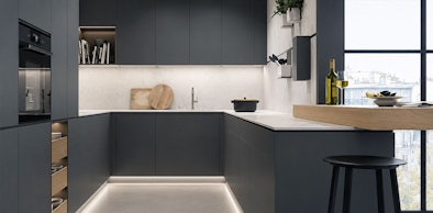 Moderne U-vorm keuken met donkere fronten en lichte werkbladen langs drie wanden