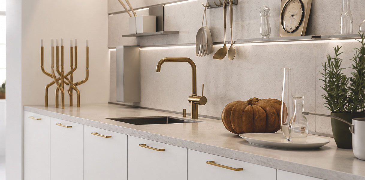 Witte keuken met messing grepen, gouden kraan en lichte achterwand