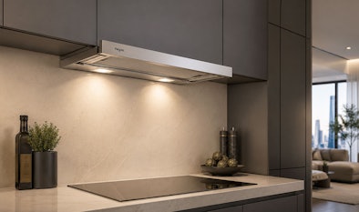 Motorloze Pelgrim afzuigkap onder een bovenkast met verlichting boven een kookplaat in een moderne keuken