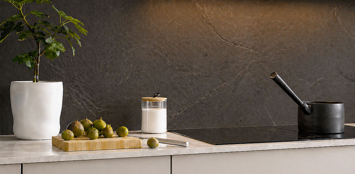 Donkere natuursteen achterwand met natuurlijke aderingen in luxe keuken