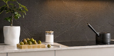 Donkere natuursteen achterwand met natuurlijke aderingen in luxe keuken