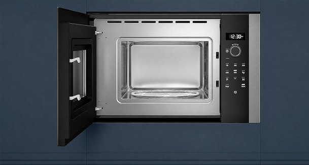 Geopende inbouwmagnetron met draaiplateau en bedieningspaneel ingebouwd in een keukenkast