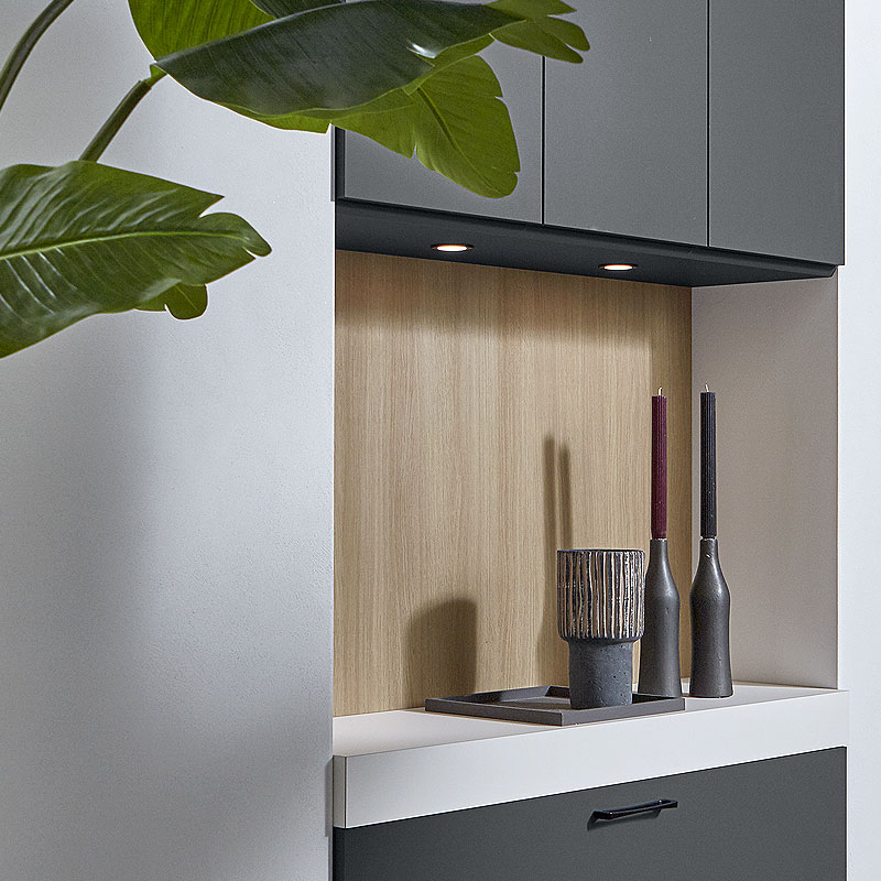 Eiken nis met geïntegreerde spots en carbongrijs omlijsting.