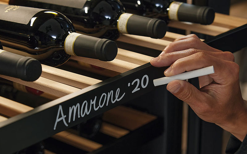 Hand schrijft Amarone 2020 op Miele NoteBoard krijtsysteem voor professionele wijncollectie