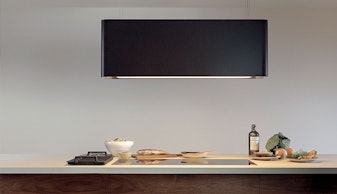 Novy design afzuigkap met geïntegreerde verlichting boven een keukenblok met gerechten