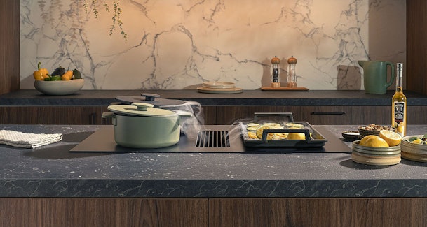 Novy Easy Matte Line kookplaat met afzuiging in kookeiland waarbij stoom van pannen direct via het middenrooster wordt afgezogen.