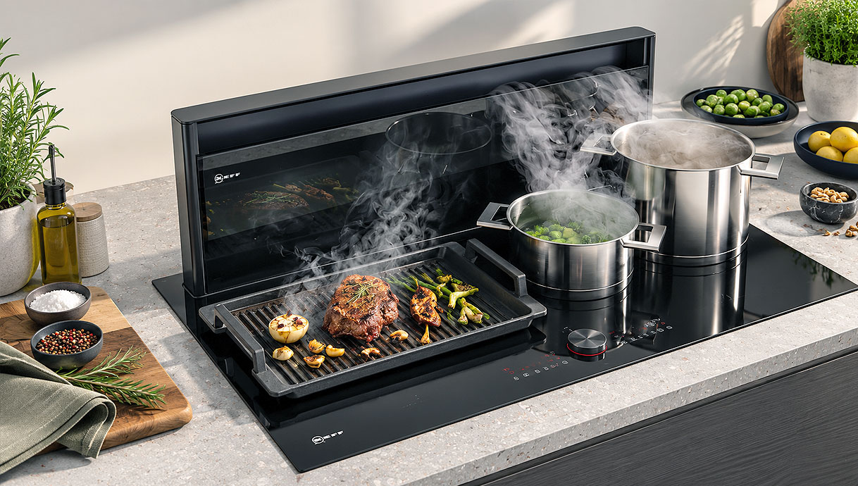 Novy Panorama brede kookplaat met afzuiging waarop grillplaat en twee dampende pannen staan