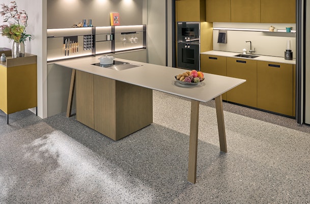 Olijfgele keuken met kooktafel.