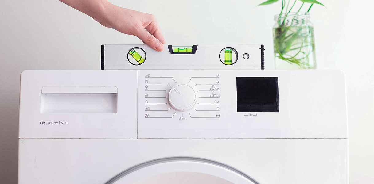 Waterpas op een wasmachine om te controleren of deze recht staat