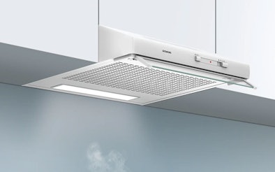 Onderbouw afzuigkap gemonteerd onder een keukenkastje die kookdampen en geuren boven de kookplaat afzuigt.