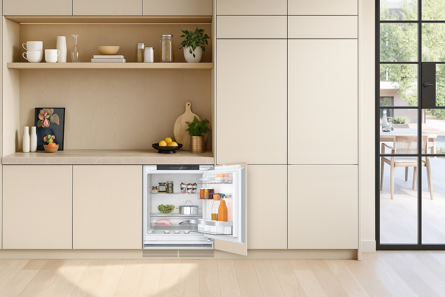 Onderbouw koelkast in lichte keuken, geïntegreerd onder het werkblad met open deur en compacte indeling.