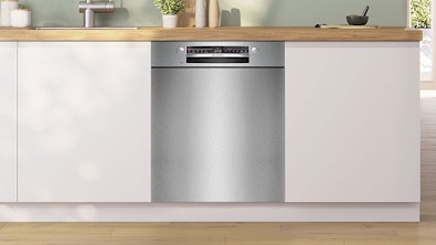Onderbouw vaatwasser geïntegreerd in moderne witte keuken met houten werkblad