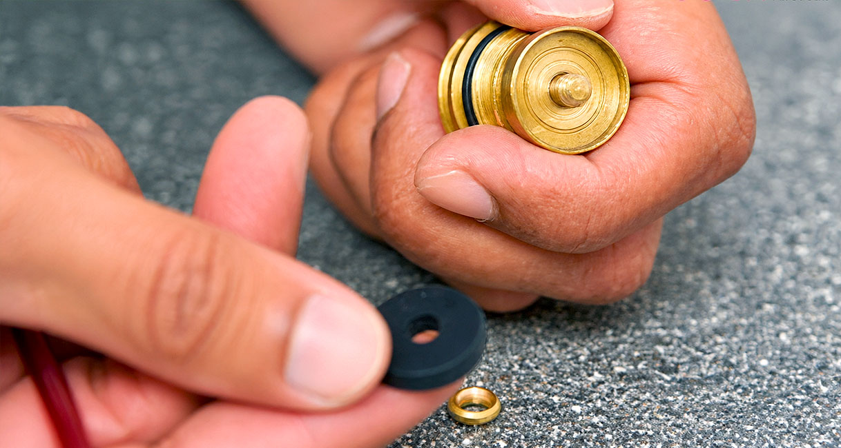 Gedemonteerd binnenwerk van keukenkraan met rubberen ring en sluitring die op volgorde worden gelegd